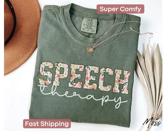 May include: A green t-shirt with the words "SPEECH therapy" in white lettering with a floral pattern. The shirt is made of a soft, comfortable fabric.