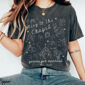 A must-have for any engaged bride, this customized Going to the Chapel Comfort Colors shirt is a stylish and sentimental keepsake for wedding festivities.