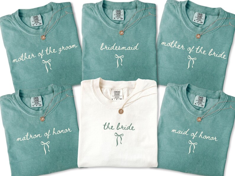 Flat lay of bridal party shirts featuring maid of honor matron of honor bridesmaid and mother roles. Designed for coordinated getting ready outfits on the wedding morning.