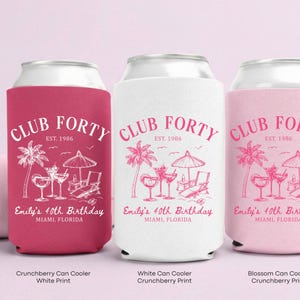 Three colorful can coolers with the text "Club Forty" printed on them, each representing a different color: pink, white, and pink.
