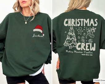 May include: A forest green crewneck sweatshirt featuring a small red and white Santa hat graphic with the name Jackson printed below on the front. The back displays a large white graphic with the text Christmas Crew, Making Memories Together, and Miami Beach 2026, surrounded by illustrations of a Christmas tree, gingerbread man, stocking, and candy cane.