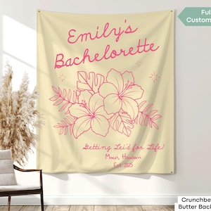 May include: A cream-colored wall tapestry with pink text and floral graphics. The text reads "Emily's Bachelorette" and "Getting Lei'd for Life! Maui, Hawaii Est. 2025." Features a hibiscus flower design. Fully customizable.