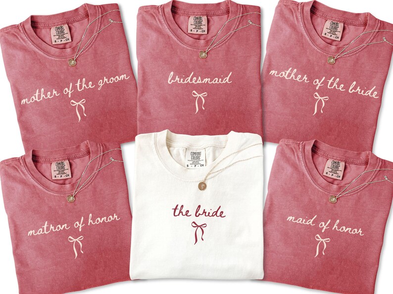 Bridal party shirts laid flat highlighting elegant lettering and soft fabric. Created for matching bridesmaid outfits and meaningful wedding party gifts.
