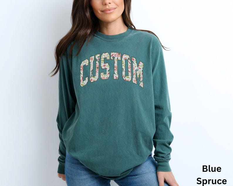 Ideal as a thoughtful and personalized gift, this long sleeve custom t-shirt lets you create a unique message with its floral college letter design.