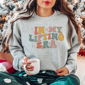 Trendy sweatshirt with a retro In My Lifting Era design. Perfect for women who love lifting weights and showcasing their strength in style.
