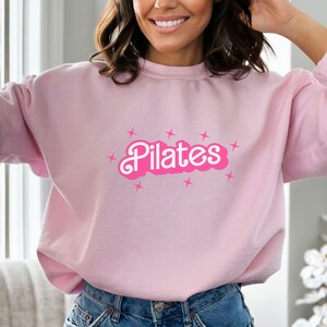 Pilates Coach shirt a great gift for Pilates coaches, offering a comfortable and stylish way to represent their role while staying active and fashionable