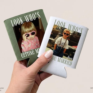 May include: Two foam can coolers, one moss green with white text and one white with moss green text. Each features a photograph of a child wearing sunglasses and the printed text "LOOK WHO'S GETTING MARRIED". The white cooler includes the name "James".