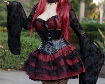 May include: Calendar page featuring a woman in a gothic-style outfit. The ensemble includes a red and black dress with a corset, fishnet stockings, and long, flowing sleeves. The calendar year "2026" is visible at the bottom.