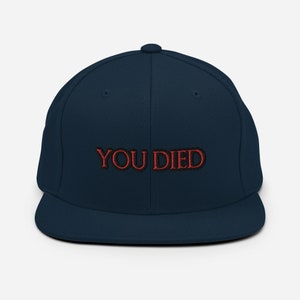May include: A navy blue baseball cap with a red embroidered "YOU DIED" text.