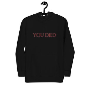 May include: Black hooded sweatshirt with the text "YOU DIED" in red.