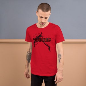 May include: A red short-sleeved t-shirt with a black graphic of a skeletal figure and the text "YOU DIED".