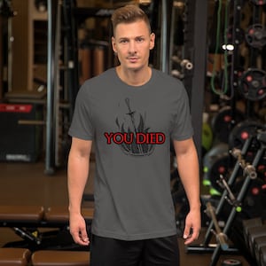 May include: A dark grey t-shirt with a black and white graphic of a sword engulfed in flames. The text "YOU DIED" is in red.