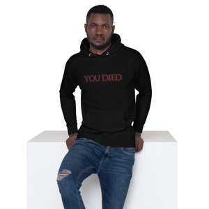 May include: A black hooded sweatshirt with the text "YOU DIED" in red outlined letters.