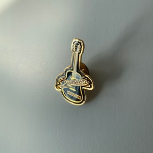 Pin de guitarra. Bronson, Misuri. Pin de esmalte. Accesorio de ropa. Pin de solapa. Recuerdo. Promocional.