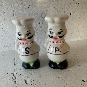 Chefs. Salt and Pepper. Vintage porcelain salt and pepper shakers. White and black with red. Chef’s hat. Pair of shakers. Vintage seasoning.