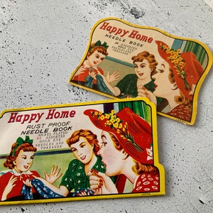 May include: Two vintage needle books with illustrations of women sewing. The top book is yellow with the text "Happy Home Needle Book 30 Assorted Gold Eye Needles and Threader". The bottom book is yellow with the text "Happy Home Rust Proof Needle Book Nickel Plated 60 Assorted Gold Eye Needles and Threader".