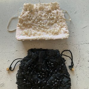 以下が含まれることがあります： ビーズの巾着袋が2つ。1つは白地にパールのようなビーズ、もう1つは黒地に黒いビーズで飾られています。
