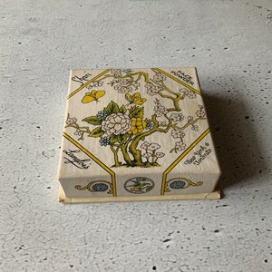 May include: A white box with a yellow and green floral design. The box is labelled "Face Powder" and "Langlois" with the text "New York & Toronto".