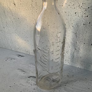 Stork Rexall baby bottle. Embossed. Peter Rabbit. 8 oz. Graduated. Under 7 inches tall. Antique and vintage collectible bottles. Glasswares.