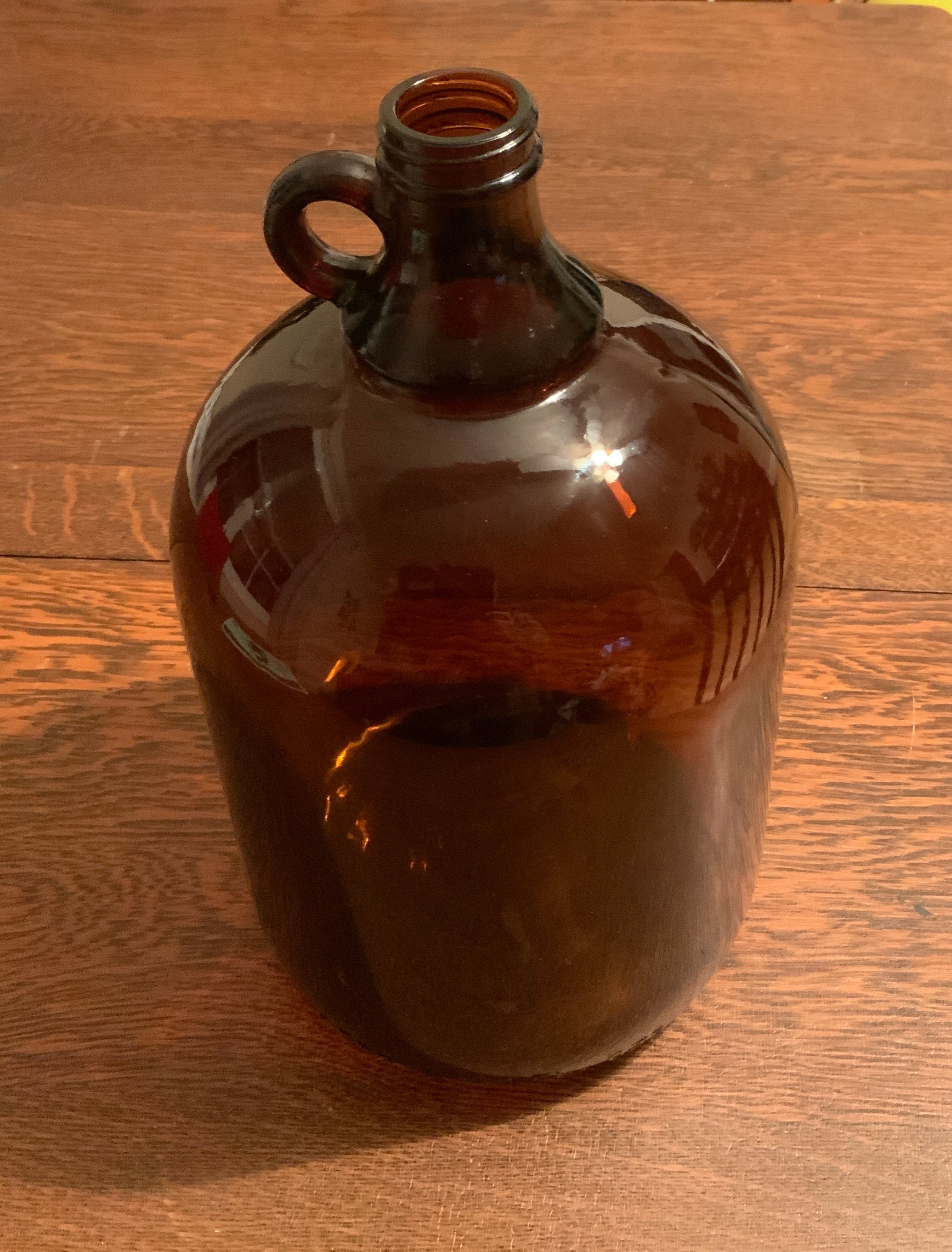 c. 1920's original dark amber colored american industrial oversized one  gallon glass laboratory screw top jug with integrated circular-shaped handle