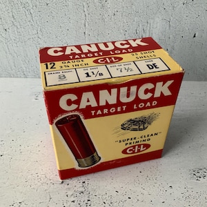 Carga Canuck Target. Caja de 25 cartuchos. C-I-L. Calibre 12. Material deportivo antiguo. Cartón. Cebado superlimpio. Perdigones DE de 1 1/8 oz. Caja vacía.