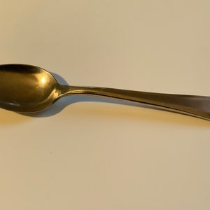 Puede incluir: Una cucharadita de plata con un cuenco redondeado y un mango ligeramente curvado.