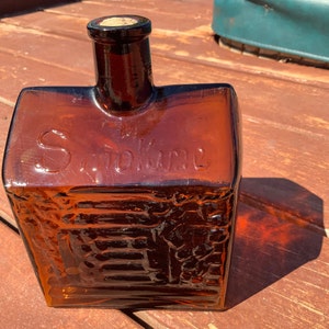 Log cabin bottle. 1900-1905. Andresen and Co.  Smokine bottle. Winnipeg. Brown glass. Amber glass. Rare bottle.