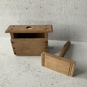 Puede incluir: Una taza de cerámica blanca con un asa negra y el texto "But First, Coffee" en negrita negra. La taza se encuentra sobre un fondo neutro, resaltando su diseño simple.