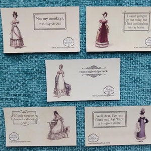 May include: Five white cards with black text and illustrations of women in vintage dresses. The text on the cards reads: "Not my monkeys, not my circus", "I wasn't going to go out today, but I look too fabulous to stay home", "I run a tight shipwreck", "If only sarcasm burned calories", and "Well, drat. I've just found out that "Earl" is his given name."