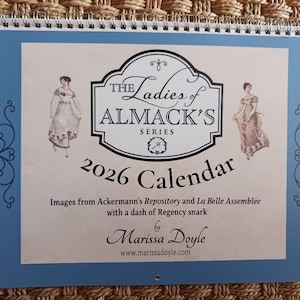 May include: A spiral-bound 2026 calendar with a blue border features the text "The Ladies of Almack's Series." It includes images from Ackermann's Repository and La Belle Assemblée, with a Regency theme, by Marissa Doyle.