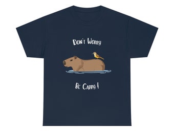 May include: Navy blue t-shirt with a cartoon capybara and a bird on its back. The text "Don't Worry Be Cappy!" is printed on the shirt.