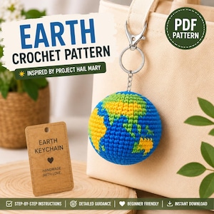May include: A crochet Earth keychain featuring a spherical globe with blue oceans and yellow and green continents. The globe is attached to a silver metal lobster clasp and keyring. A brown paper tag reads EARTH KEYCHAIN HANDMADE WITH LOVE.