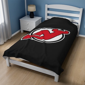 May include: Black twin-size bedspread featuring the New Jersey Devils logo in red and white.