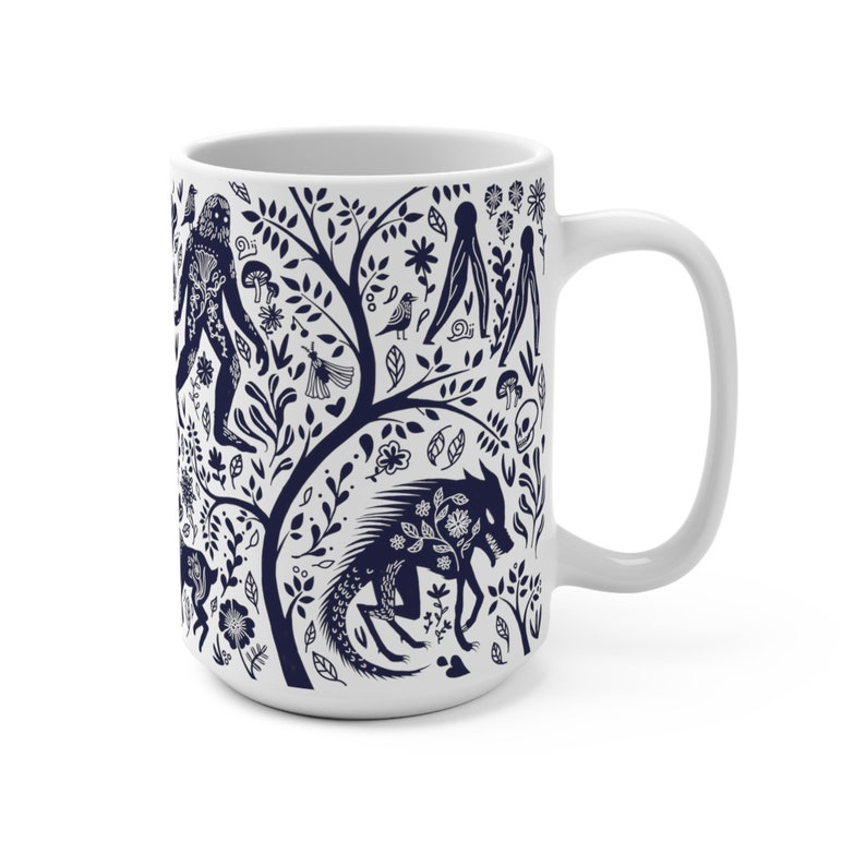 K&ouml;nnte beinhalten: Wei&szlig;e Keramiktasse mit einem blauen und wei&szlig;en Design, das einen Baum mit verschiedenen Kreaturen und Pflanzen zeigt. Das Design beinhaltet einen Wolf, einen Bigfoot, einen Vogel und eine Schnecke.