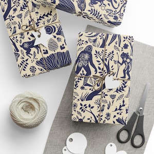 May include: Gift-wrapped presents with navy blue botanical and animal illustrations on cream-colored paper. Each package is tied with twine and a white tag. A ball of twine, scissors, and blank tags are also visible.