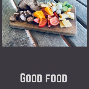 May include: A wooden cutting board with a variety of food items, including sliced bread, sausage, cheese, tomatoes, cucumbers, and yellow peppers. The text "GOOD FOOD GOOD MOOD" is printed below the board.