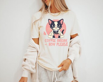 May include: A white t-shirt with a black and white cartoon cat wearing a doctor's coat and holding a cup of coffee. The text "Coffee Break - Now Please" is printed below the cat.
