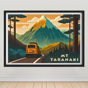 May include: A vintage yellow van drives along a winding road through a lush green forest towards a mountain peak. The mountain is called "MT TARANAKI" in a retro font.