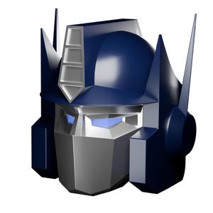 Op de afbeelding: Een 3D-weergave van het hoofd van Optimus Prime, met een donkerblauwe helm en zilveren gezichtsbedekking. Het ontwerp heeft hoekige vormen en details, tegen een witte achtergrond.