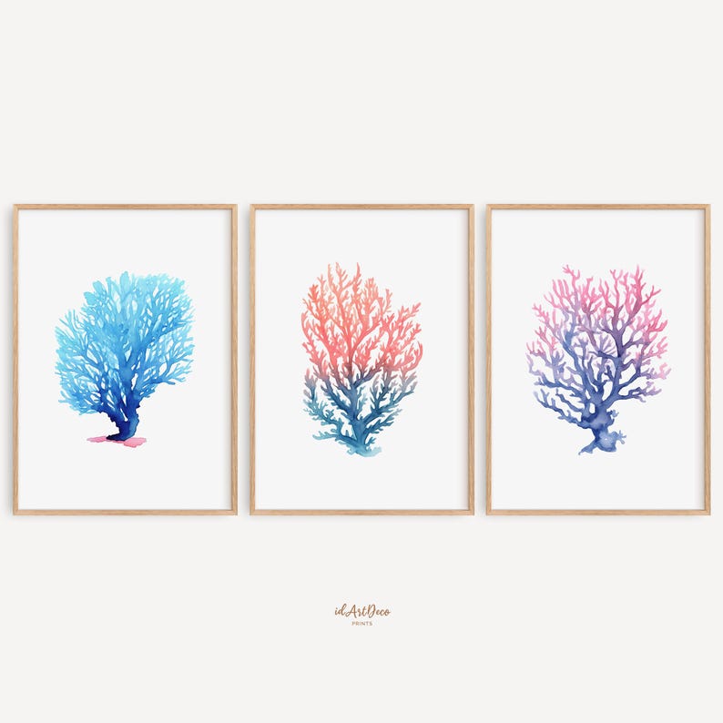 May include: Set of three watercolour prints featuring coral in shades of blue, pink, and orange. The prints are framed in natural wood frames.