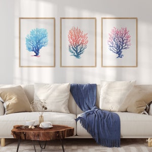 May include: Three watercolour prints of coral, each with a different colour gradient. The left print is blue, the middle print is pink and blue, and the right print is red and blue.
