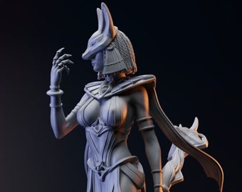 May include: A detailed, gray statue of a female figure with a jackal-like head, wearing a headdress and flowing garments. She holds a sword and has arm cuffs. The statue is set against a dark background.