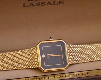Raro reloj Seiko Lassale 6020 Gold Tank de los años 80 con esfera negra. En caja.