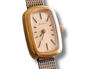 Reloj Bulova vintage para mujer de los años 50, chapado en oro, rectangular, de cuerda manual, suizo, con brazalete de malla.