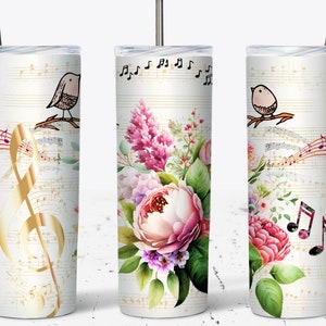 May include: A white stainless steel tumbler with a floral design and musical notes. The floral design features pink, purple, and white flowers with green leaves. The musical notes are gold and black. The tumbler has a straw.