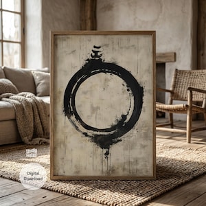 Op de afbeelding: Een ingelijst kunstwerk met een groot zwart cirkelvormig ontwerp op een beige achtergrond, gepresenteerd in een houten frame. Het kunstwerk wordt getoond in een rustieke woonkamer. De woorden "Digital Download" zijn zichtbaar.