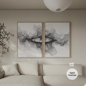 May include: Two framed art prints featuring a minimalist black and white design of a boat on water. The artwork has a line drawing style, with the boat and water reflections. The prints are displayed above a beige sofa.