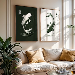 May include: Two framed art prints featuring koi fish. One print has a white koi on a dark green background with Japanese characters. The other print has a dark green koi on a white background with Japanese characters. Both are in wooden frames.