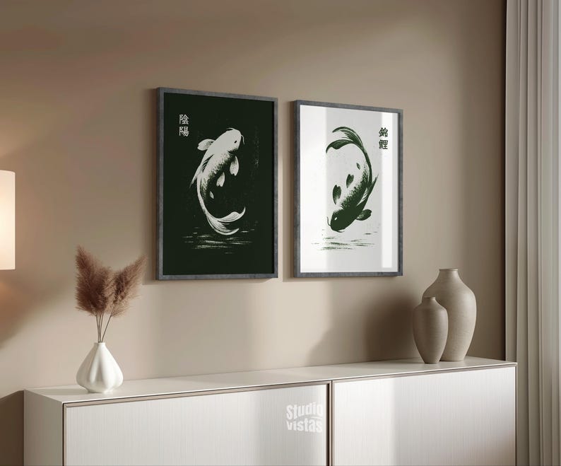 May include: Two framed art prints featuring koi fish illustrations. One print has a white koi on a black background, the other has a green koi on a white background. Both prints have Japanese characters and are displayed above a white cabinet.