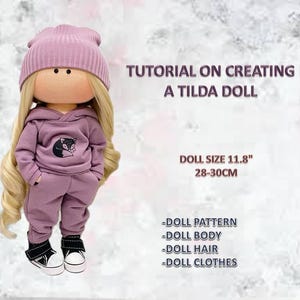 May include: A Tilda doll in a mauve tracksuit and beanie, with a fox graphic on the hoodie. The doll has long blonde hair and wears black and white trainers. The text reads "Tutorial on Creating a Tilda Doll". Doll size is 28-30cm.